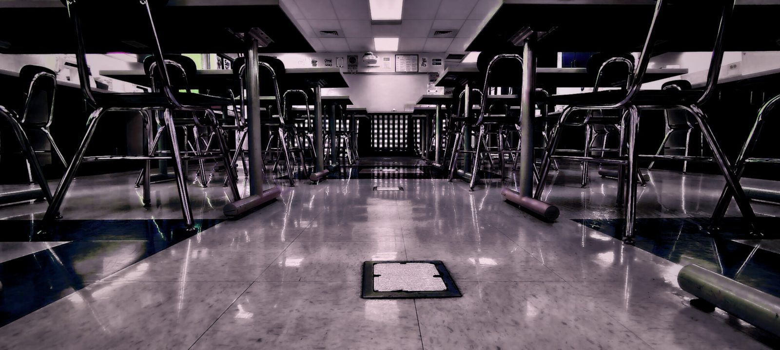 After Hours — Lancaster County. Cafeteria after the last tray. Chrome stools, linoleum, a floor drain in the center like a period. Empty on purpose.