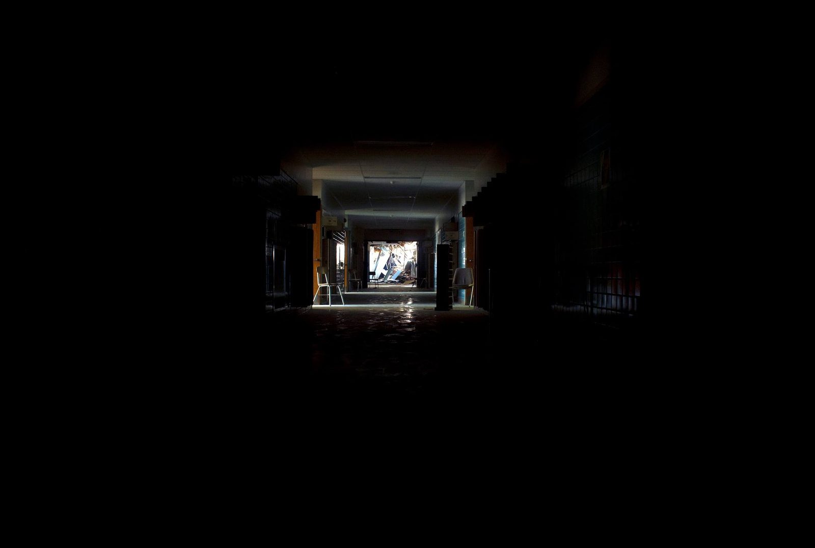 End of the Hall — Lancaster County. Another corridor, this one opening on a wrecked room. Two chairs waiting. The mess is the destination.