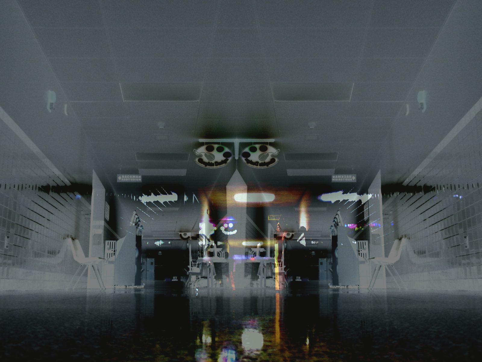 Hackman Auditorium — Lancaster County. The hallway flipped. Ceiling becomes floor. Two camera housings look like a smile. Hackman Auditorium, named on the walls.