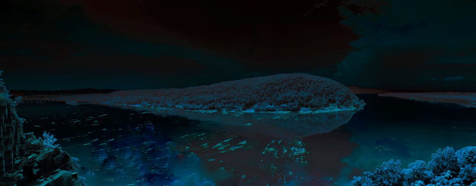 The Island — Susquehanna River. A wooded island sitting in dark water. Blue grade, long view. The river as a stage with nobody on it.