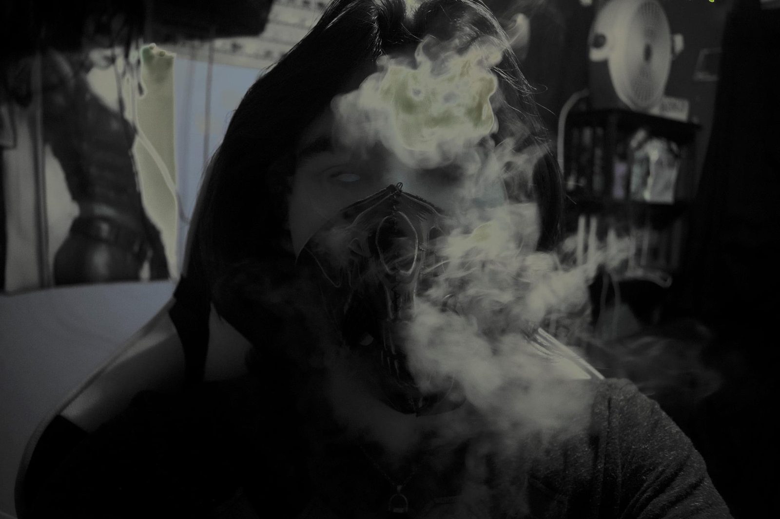 Through the Smoke — Lancaster County. Self-portrait in a mask, smoke filling the face. Black and white. The room behind is the studio, not a stage.