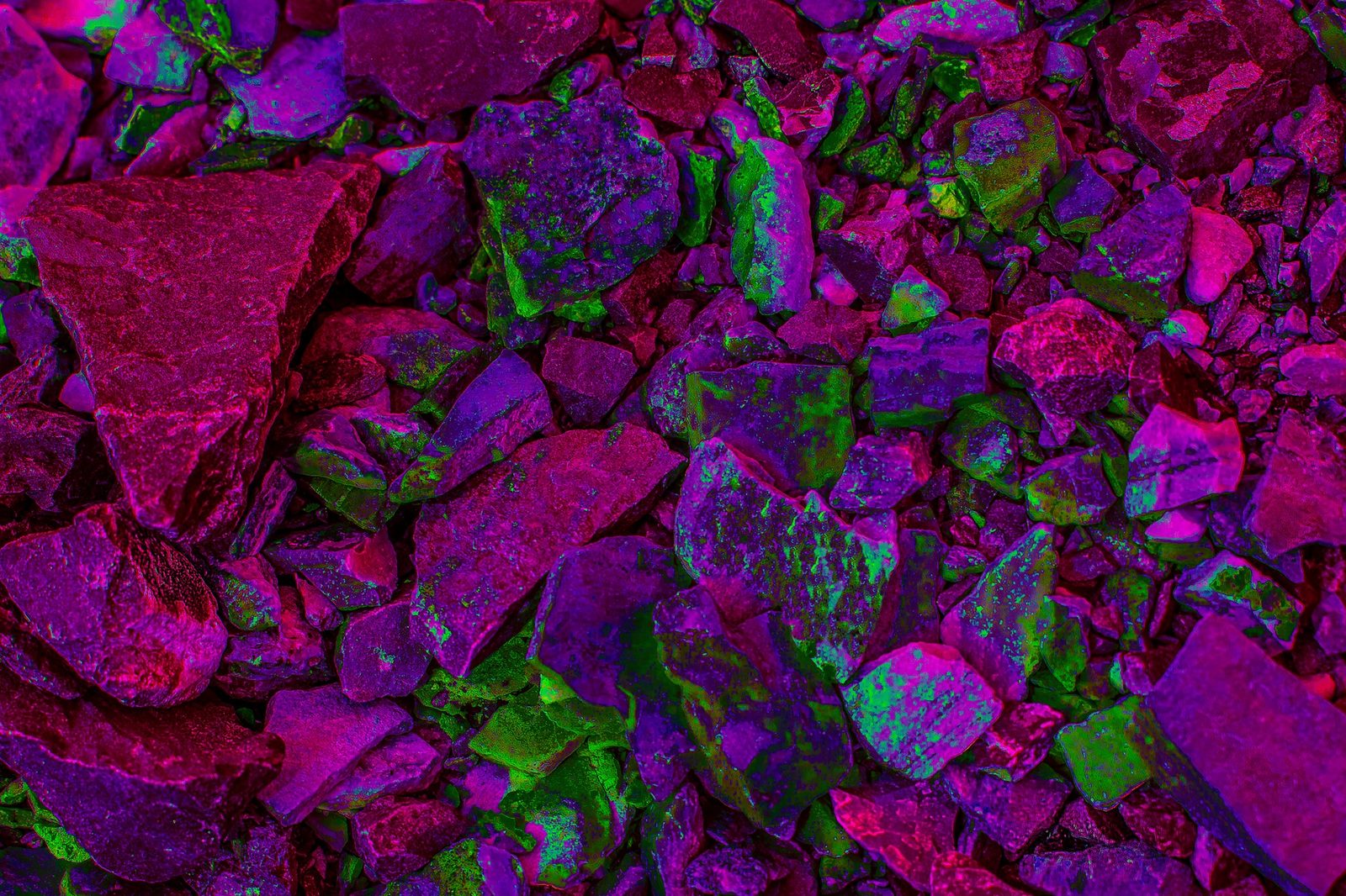 UV Field — Studio. Crushed stone under a light that makes mineral into neon. Magenta and green. Geology as a club.